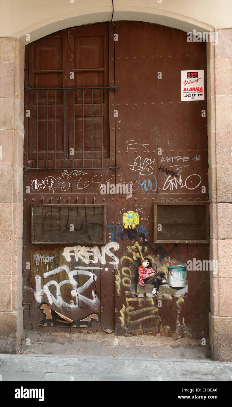 Alte Holztür mit Graffiti und Alarm melden Sie in El Raval-Viertel im Zentrum von Barcelona, Katalonien, Spanien. Stockfoto