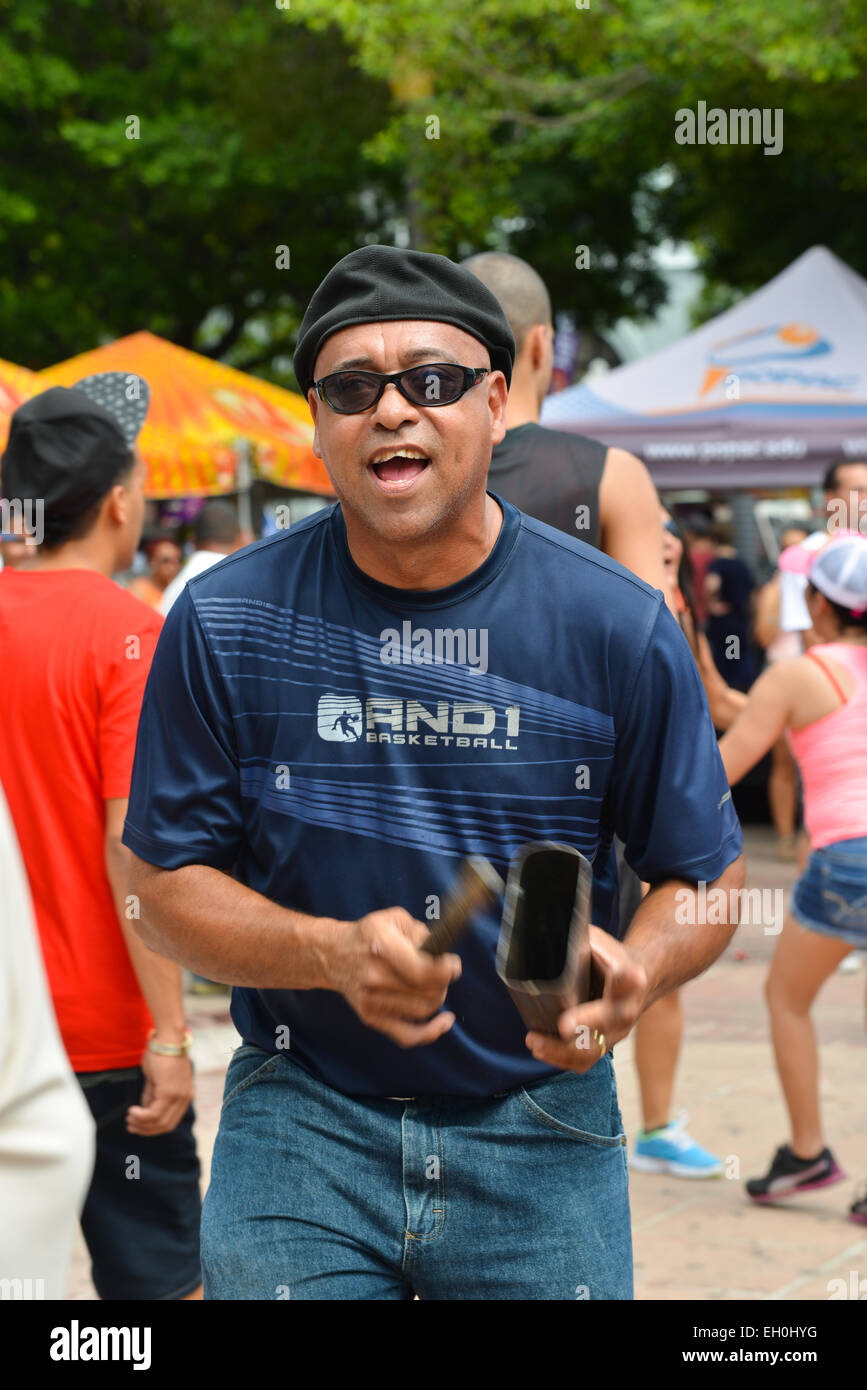Lateinischen Mann, ein Instrument zu spielen und tanzen während des Karnevals am Plaza de Las Delicias. Ponce, Puerto Rico. Februar 2015. Stockfoto
