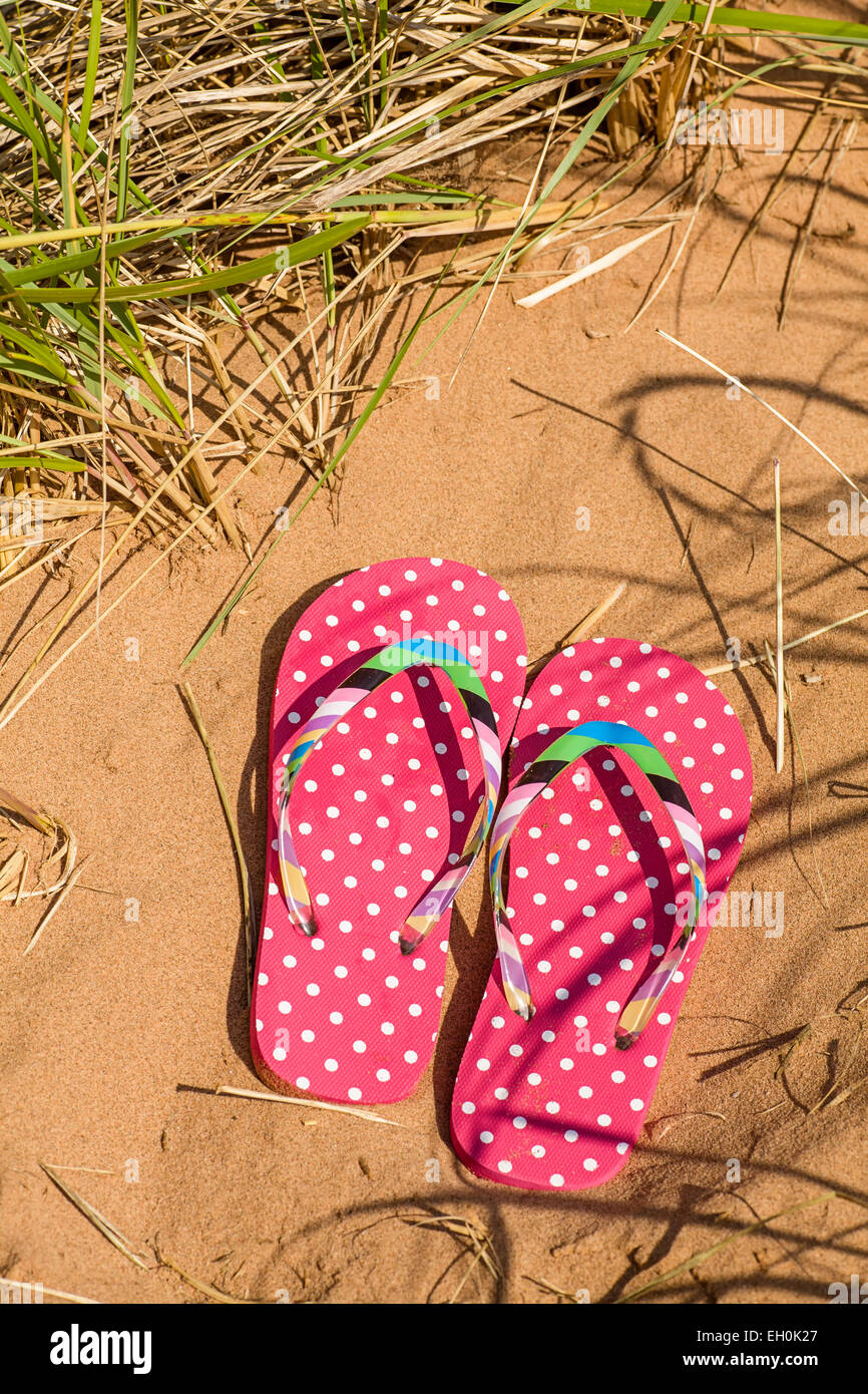 Rosa Flip Flops am Strand. Stockfoto