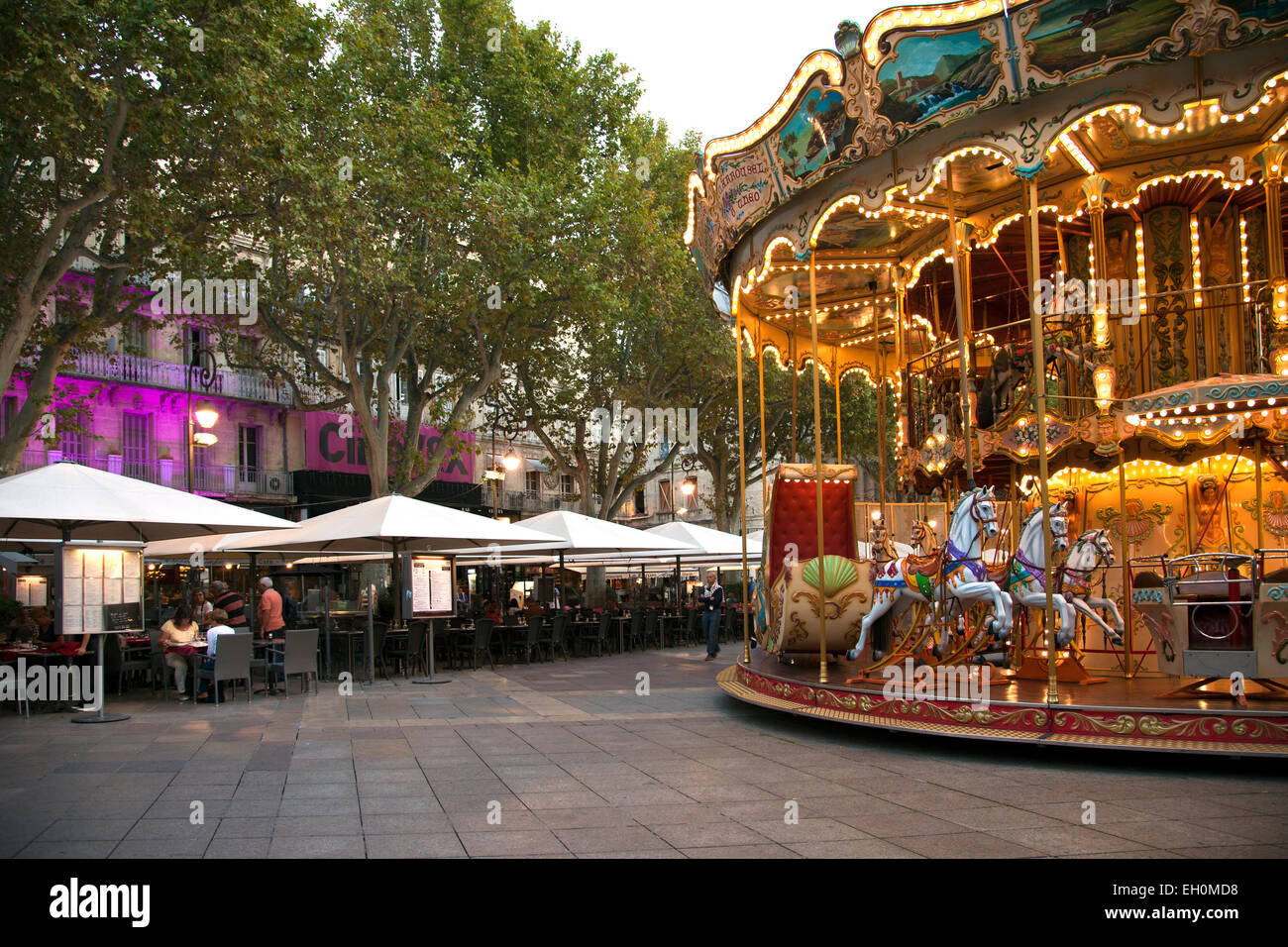 Während Spaziergänger am Abend-Angebote in einem der Cafés zu überprüfen, fügt das Karussell einen Hauch von Spaß an der Place de l ' Horloge in Stockfoto