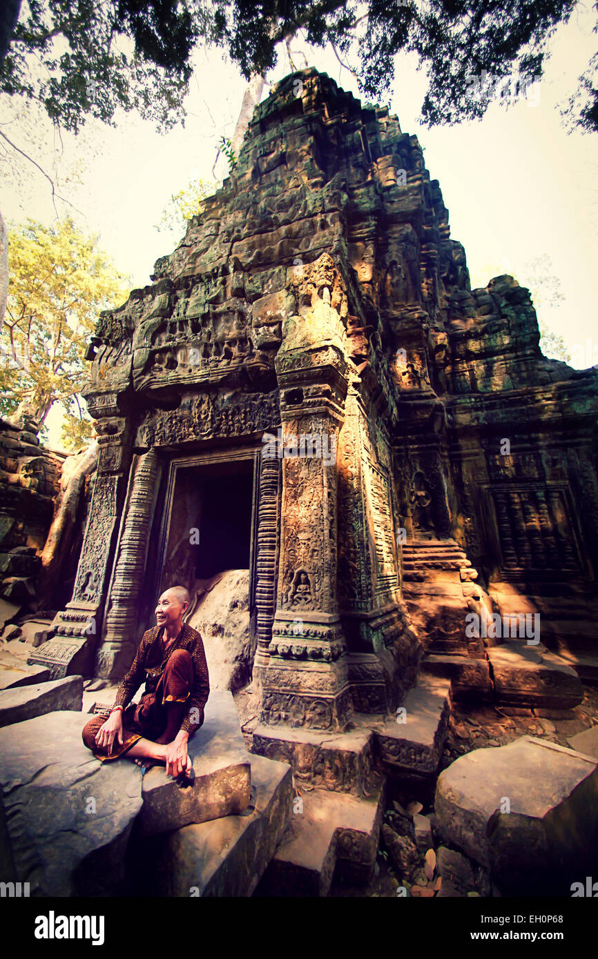 Die alte Frau ruht vor einem antiken Tempel Ta Prohm, der Tomb-Raider-Tempel in Kambodscha. Stockfoto