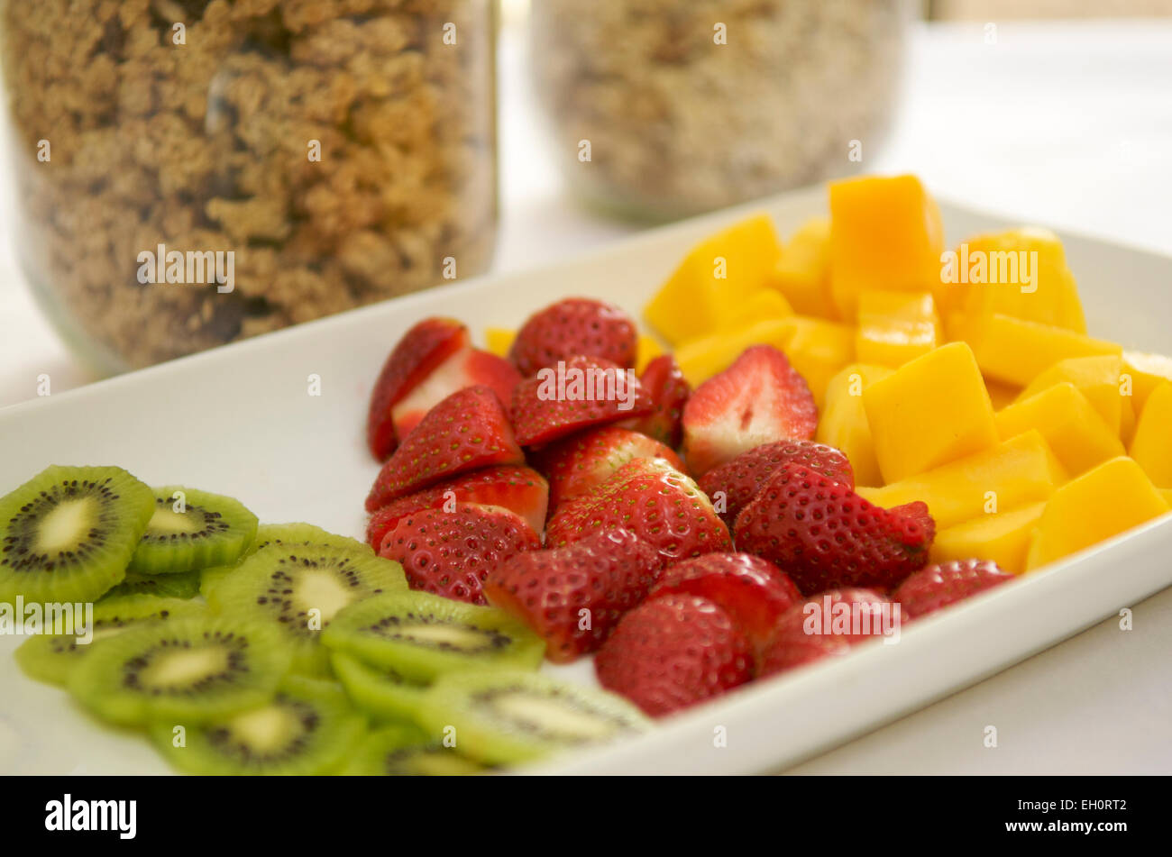 Auswahl an Früchten mit Gläsern von Müsli und Müsli zum Frühstück Stockfoto