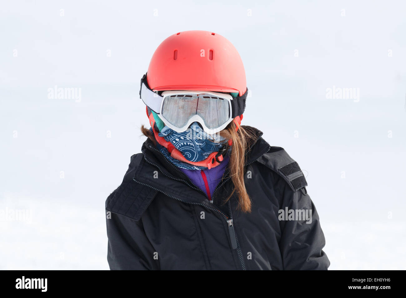 Mädchen (9 Jahre) Skifahrer Porträt eingewickelt im Ski-Ausrüstung mit orange Helm und Goggle Warm.  Keine Logos auf Kleidung Stockfoto