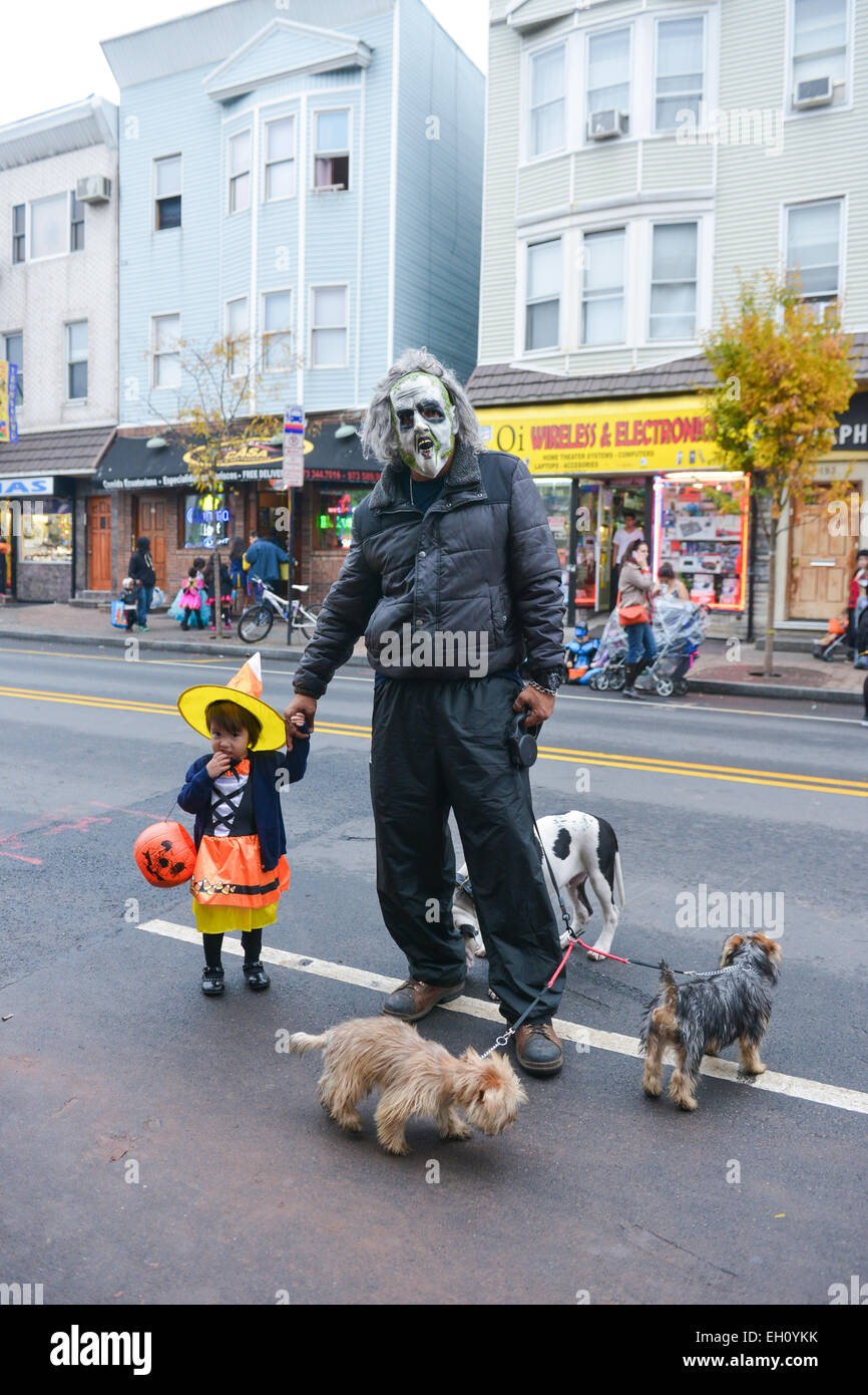 Vater Holding Töchter hand sowohl in Kostüme Halloween 2013 in den Straßen von Newark, New Jersey. Stockfoto