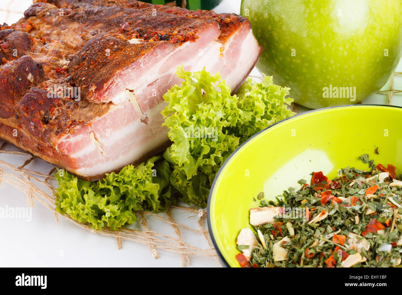 Geräucherter Speck Schweinefleisch mit grünen gesunden Salat und verschiedene Kräuter auf Tisch Tischdecke hautnah Stockfoto