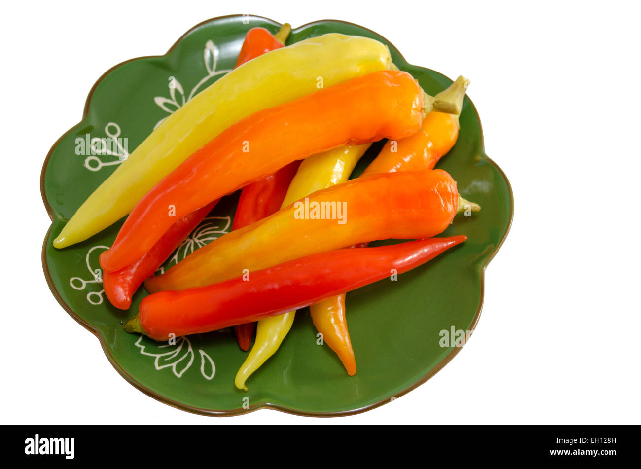 Eingelegte Paprika auf einer grünen Platte isoliert auf weiss Stockfoto