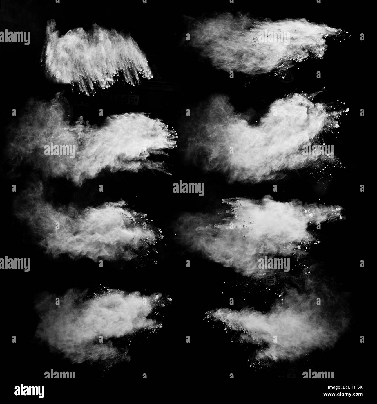 Einfrieren der Bewegung von weißen Staubexplosionen auf schwarzem Hintergrund isoliert Stockfoto
