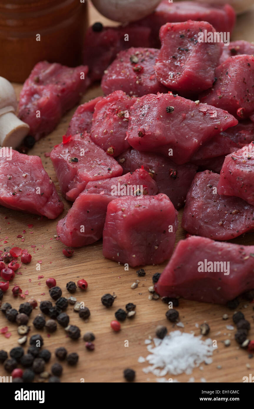 Rohes Rindfleisch in Würfel schneiden, mit Pfeffer und Meersalz gewürzt. Stockfoto