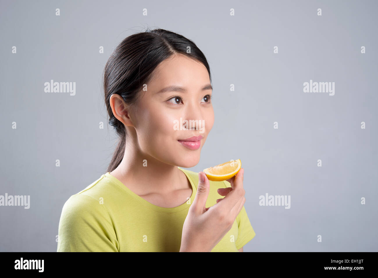 Junge Frau Essen Zitrone Stockfoto