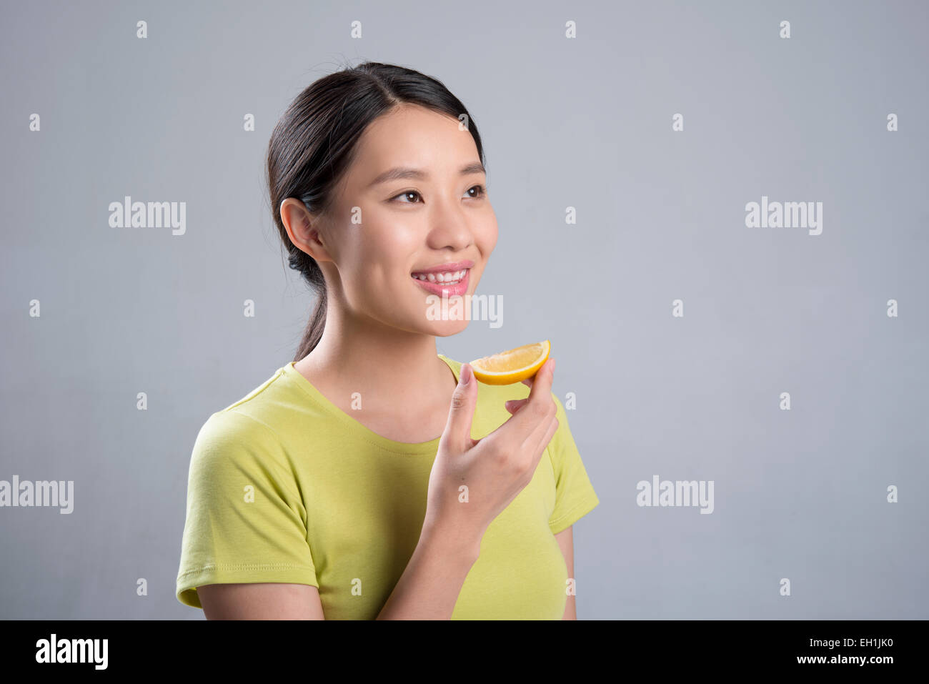 Junge Frau Essen Zitrone Stockfoto