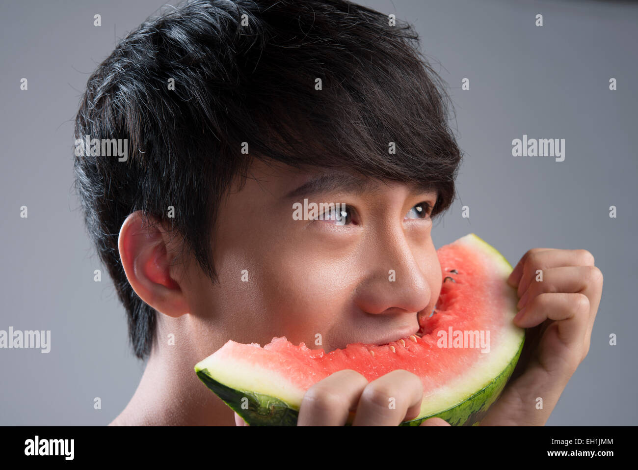Junger Mann Essen Wassermelone Stockfoto