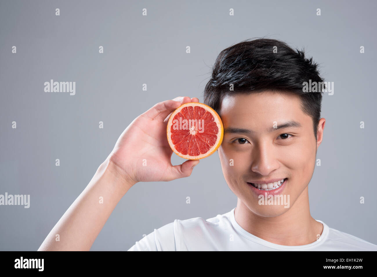 Junger Mann Essen grapefruit Stockfoto