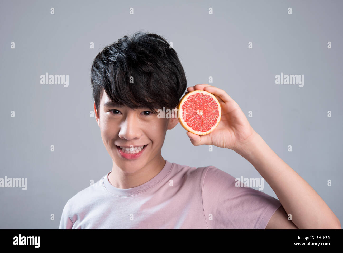 Junger Mann Essen grapefruit Stockfoto