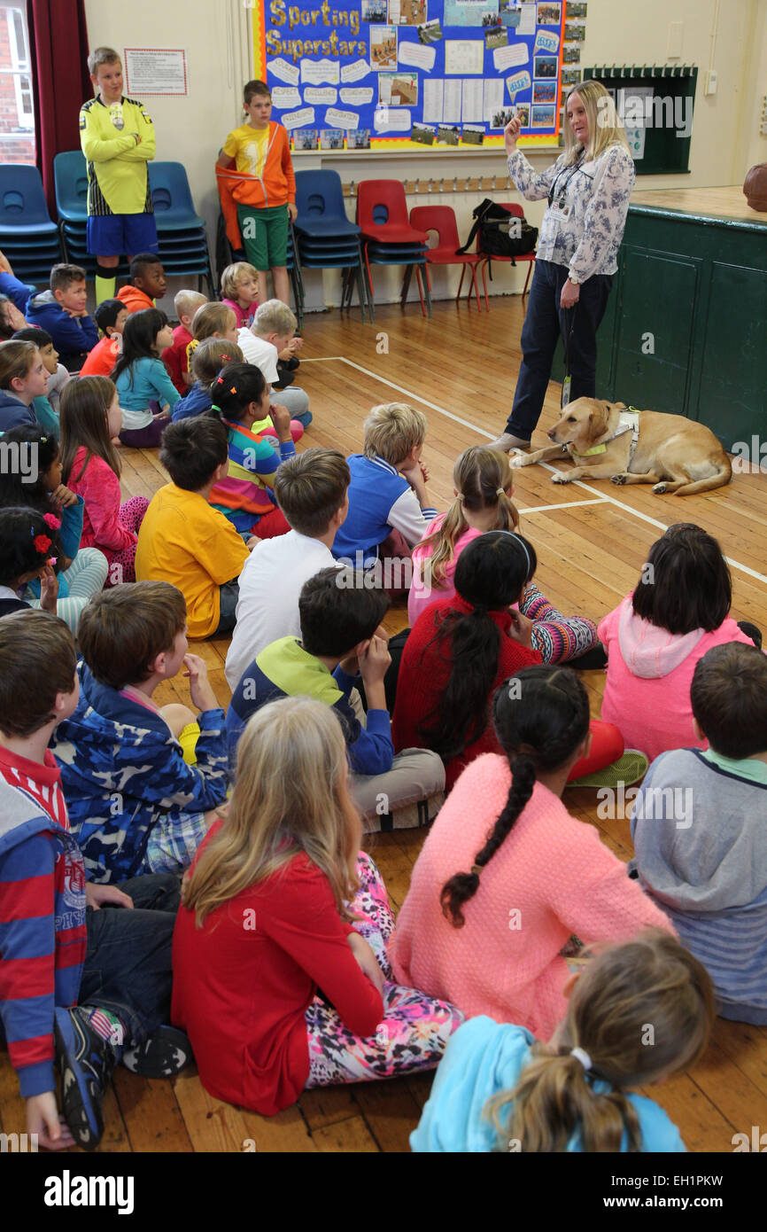 Blinde und Sehbehinderte Frau mit Blindenhund dabei Präsentation an einer Grundschule. Stockfoto