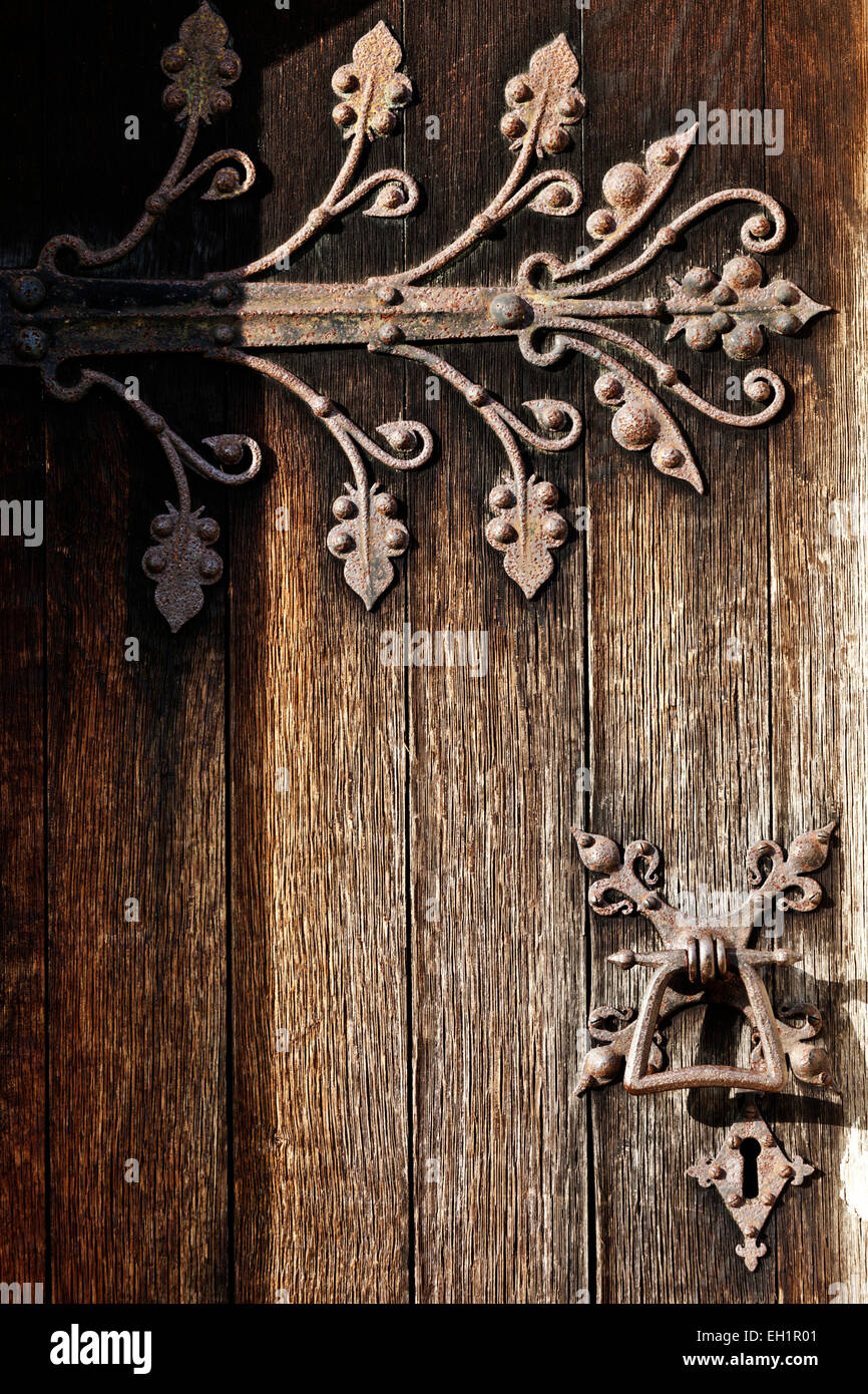 Dekorative mittelalterliche Metallscharniere schmücken eine Tür von einer alten englischen Kirche in Hertfordshire, England. Stockfoto