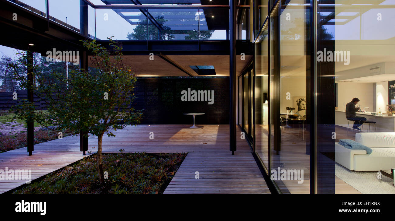 Terrasse mit Holzdeck und Baum vor Glas ummauerten modernistisches Haus, Espoo, Finnland Stockfoto