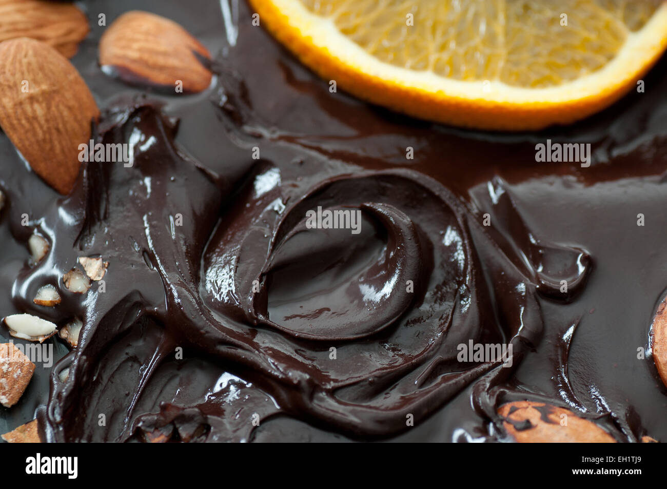 Geschmolzene Schokolade mit Mandeln und Orange. Stockfoto
