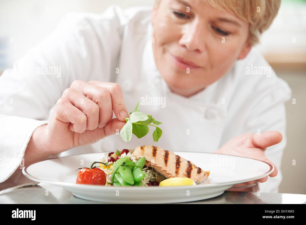Koch, Essen im Restaurant Küche Garnitur hinzufügen Stockfoto