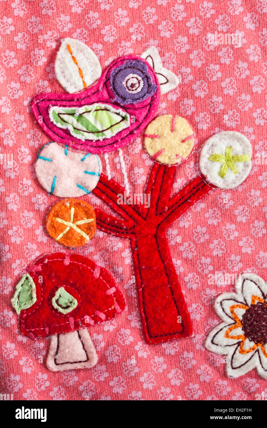 Vogel im Baum und Pilz Detail auf der Kleidung des Mädchens Stockfoto