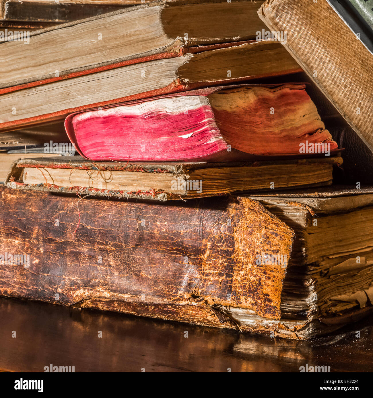 Alt, etwas vernachlässigten Bücher übereinander auf einem hölzernen Regal. Stockfoto