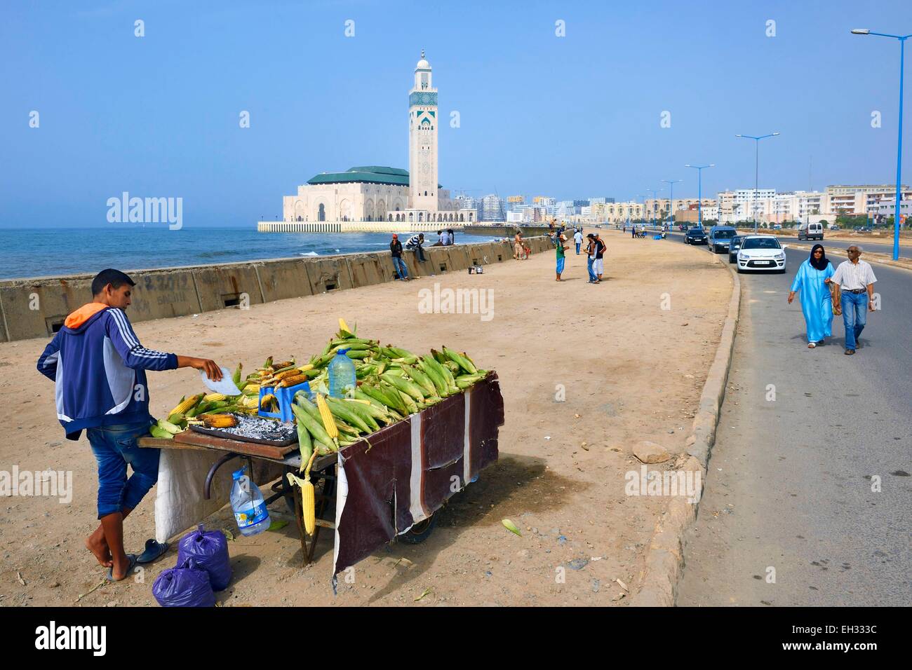 Marokko, Casablanca, Straßenverkäufer von gegrilltem Mais vor der Hassan II Moschee Stockfoto
