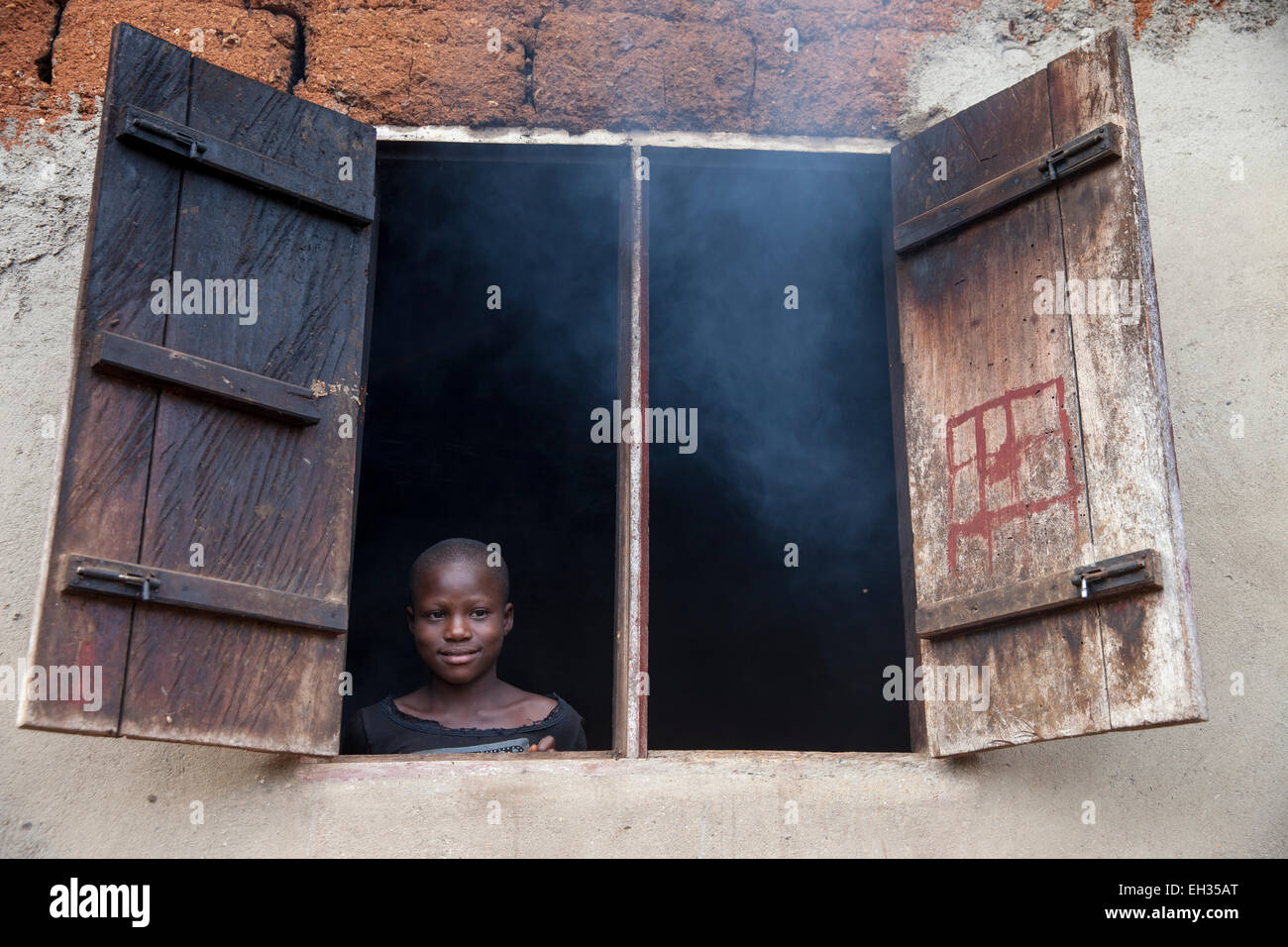 Bamenda, Kamerun, Juli 2013: Ein Team aus Sightavers Besuche Familien geben ihnen schaut Mectizan vorbeugende Behandlung für Flussblindheit als Yoiung Mädchen aus ihrem Küchenfenster. Stockfoto