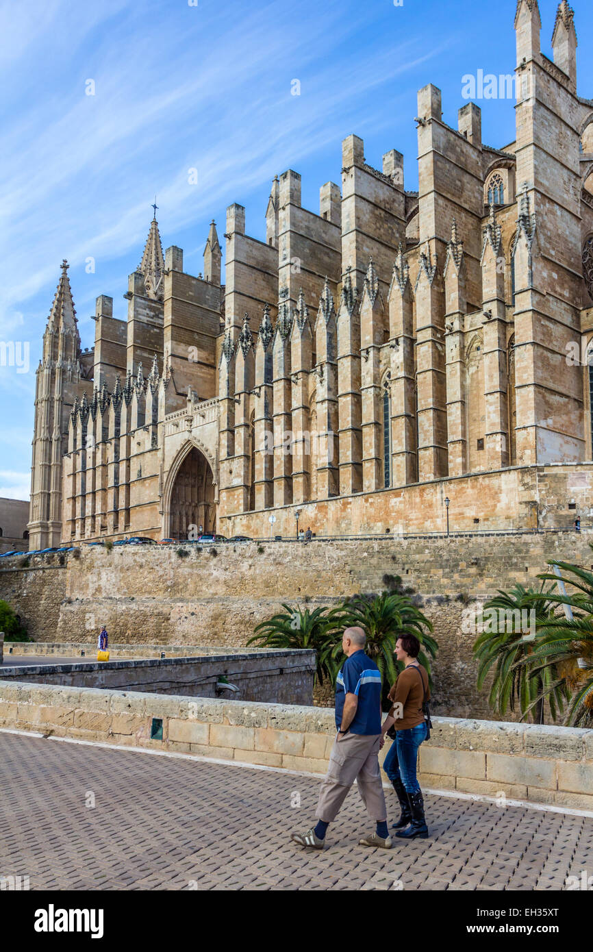 Ein Mann und eine Frau gehen vorbei an der Kathedrale von Palma La Seu. Mallorca, Spanien Stockfoto