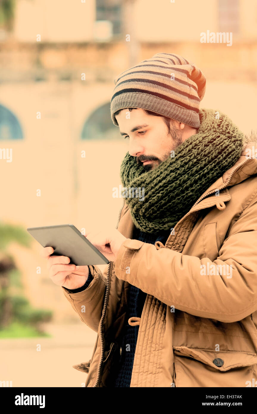 junger Mann hält eine Tabet n Mittelmeerland Instagram Filte angewendet Stockfoto