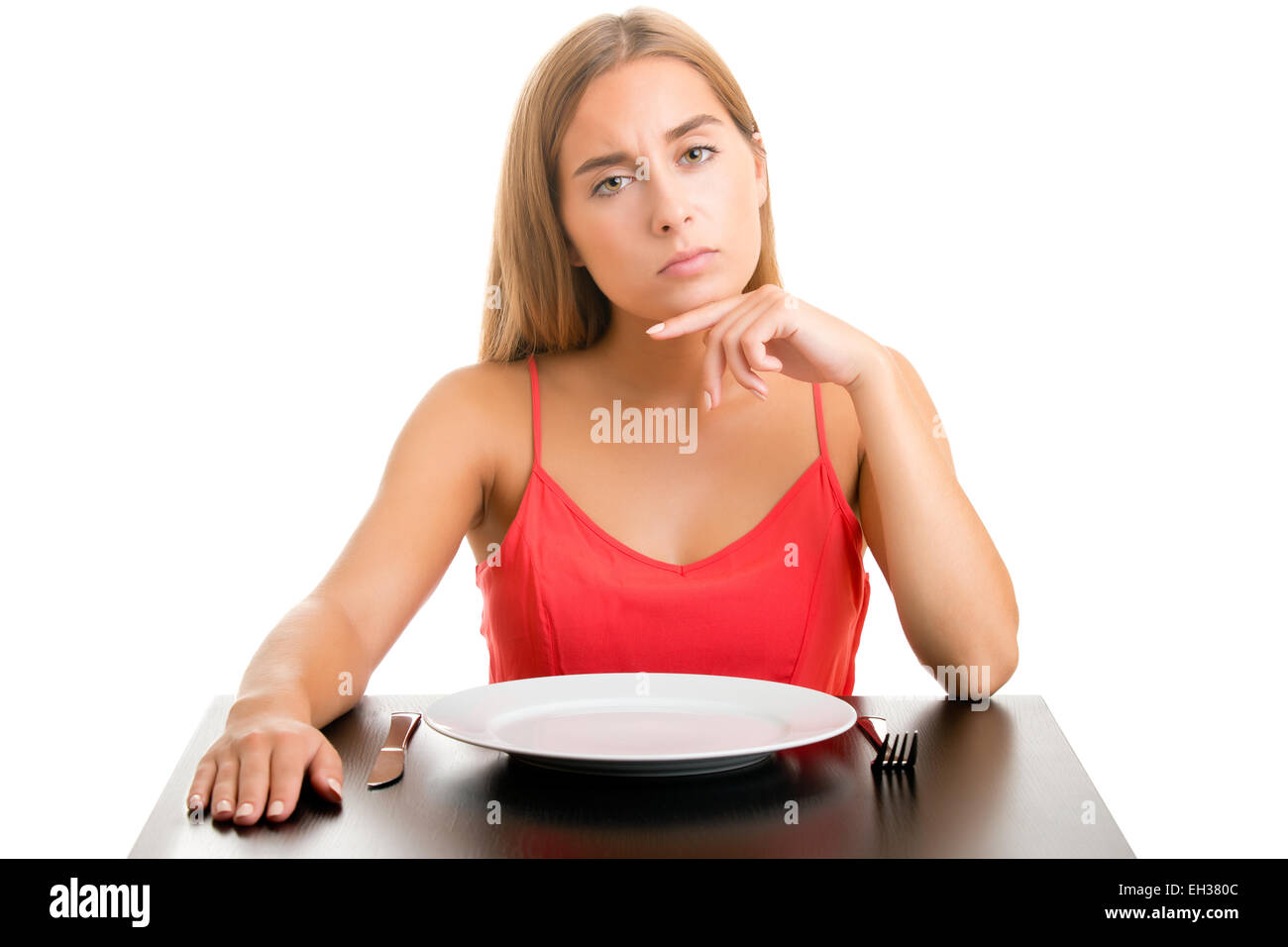 Hungrige Frau auf einer Diät wartet mit einem leeren Platz, isoliert in weiß Stockfoto