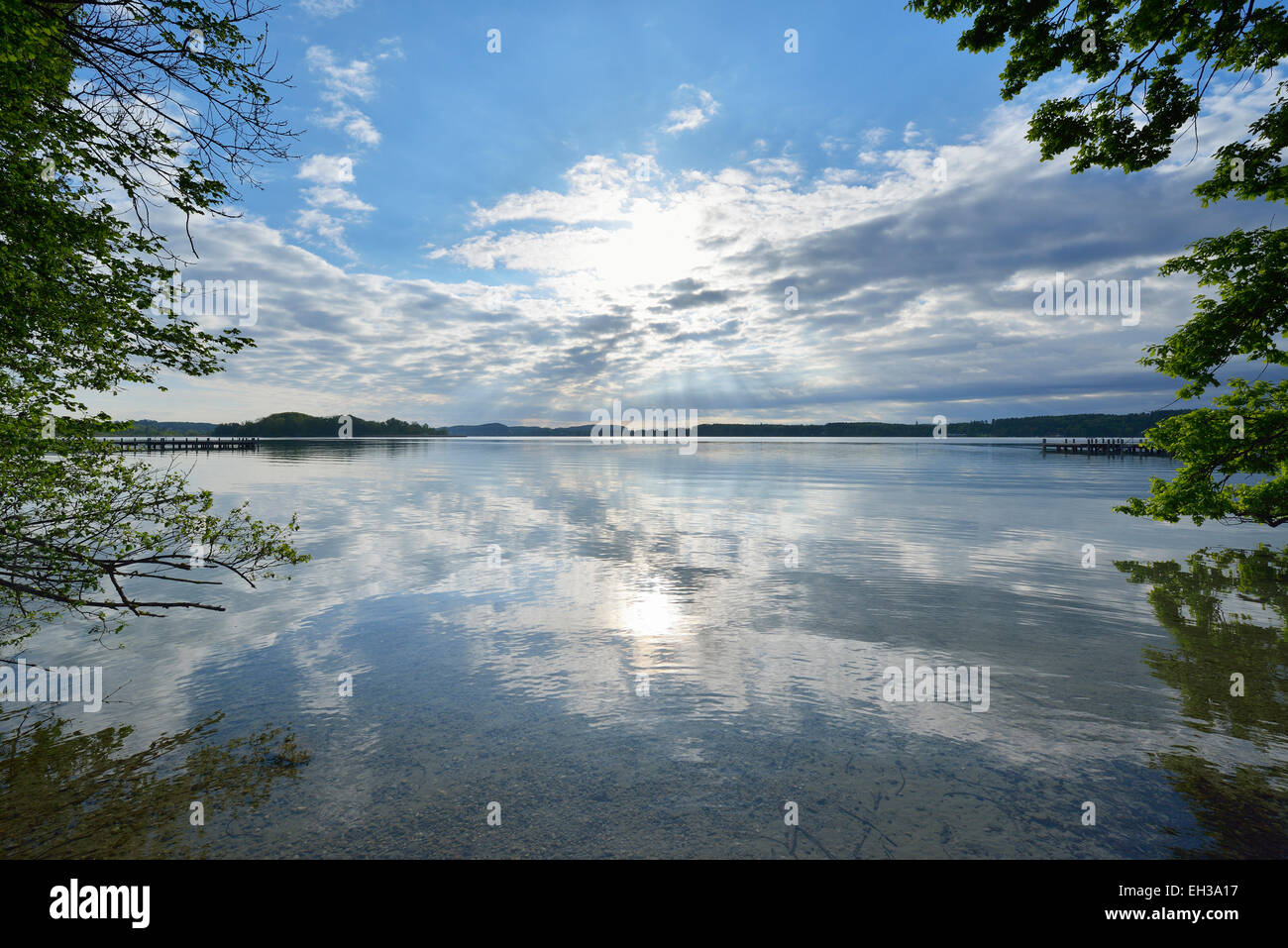 Blauer Himmel, Wolken und Sonne spiegelt sich im See, See Woerthsee, Bayern, Deutschland Stockfoto