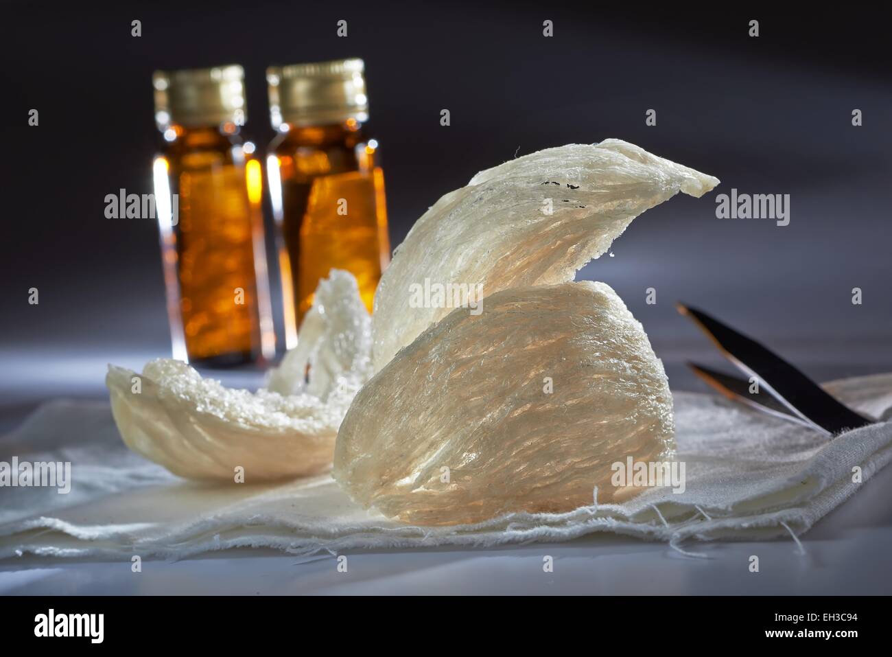 Essbare Birdnest mit Essenz Flasche und Zange in Stimmung Beleuchtung Shooting Stockfoto