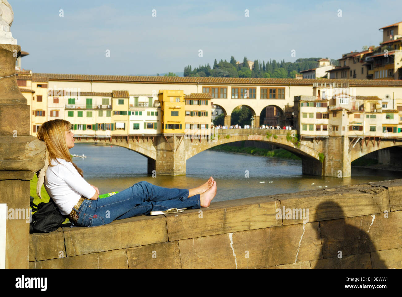 Teenager Touristen entspannen Sie sich auf die Brücke Ponte Vecchio im Hintergrund - eine berühmte Brücke über den Fluss Arno, Florenz, Italien Stockfoto