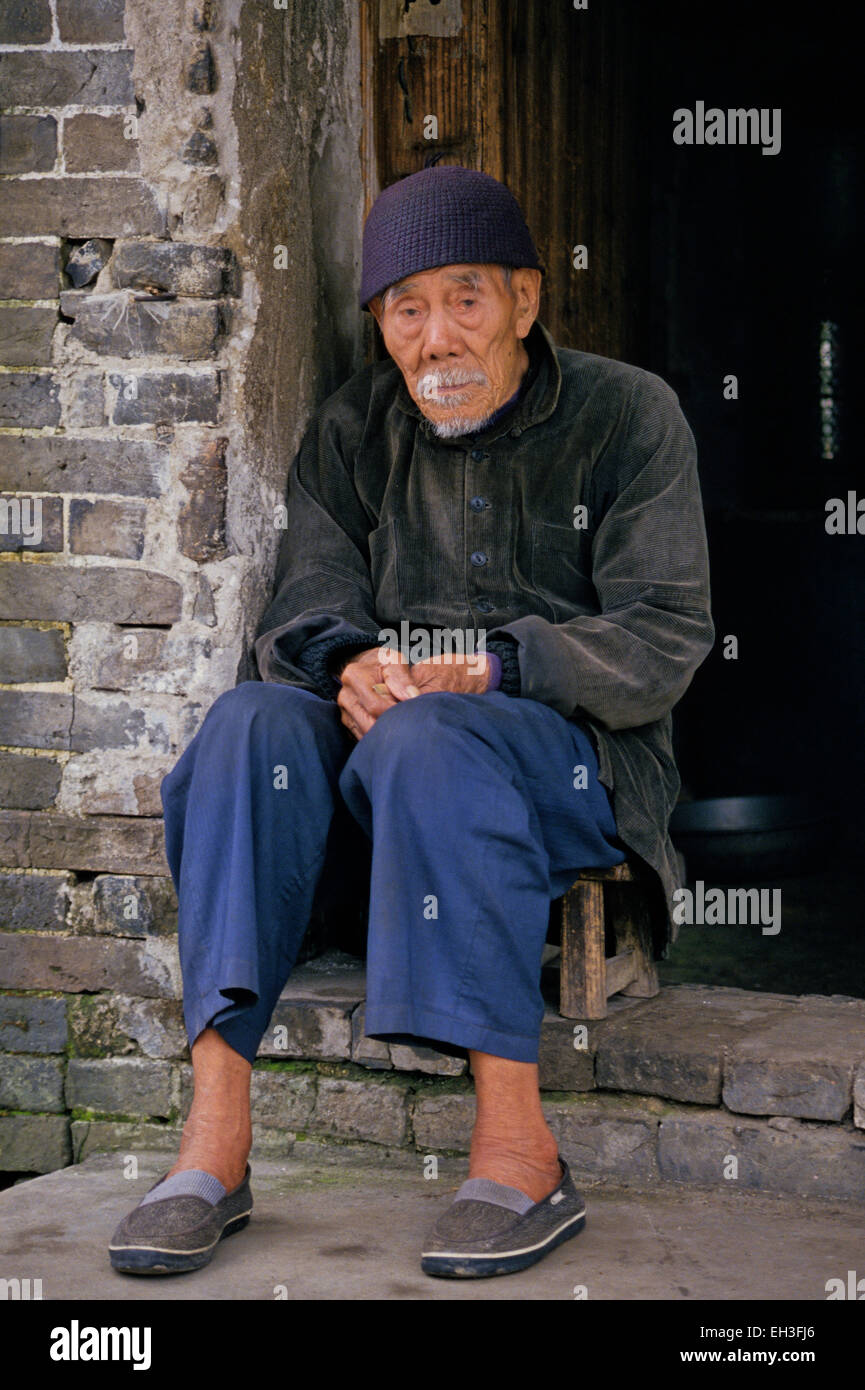 Alter Mann sitzt in Tür, Peking, China Stockfoto