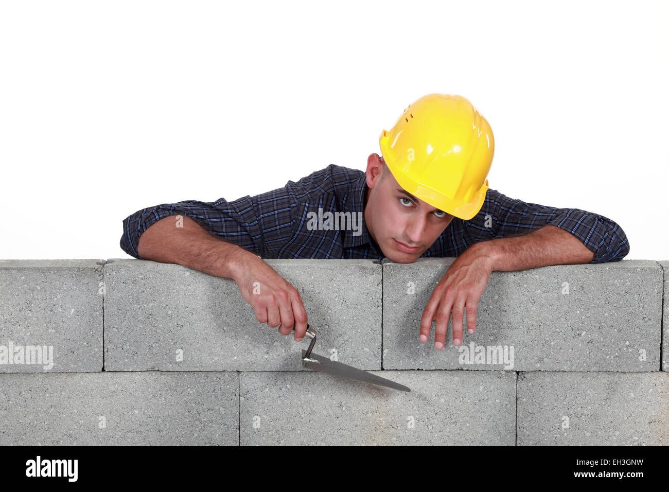Mason, stützte sich auf einer Steinmauer Stockfoto