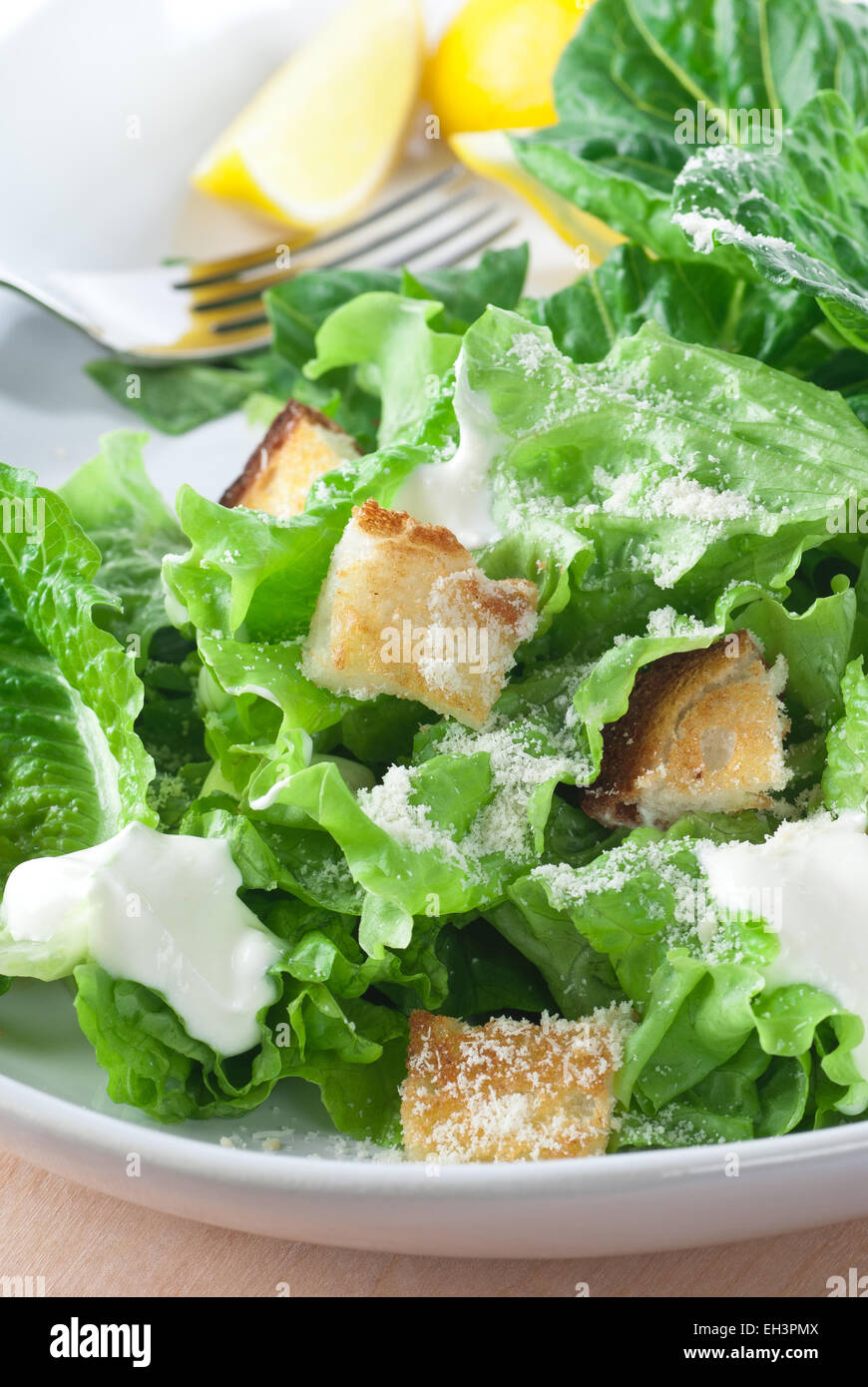 Caesar Salat mit geriebenem Parmesan, Croutons und Dressing. Stockfoto