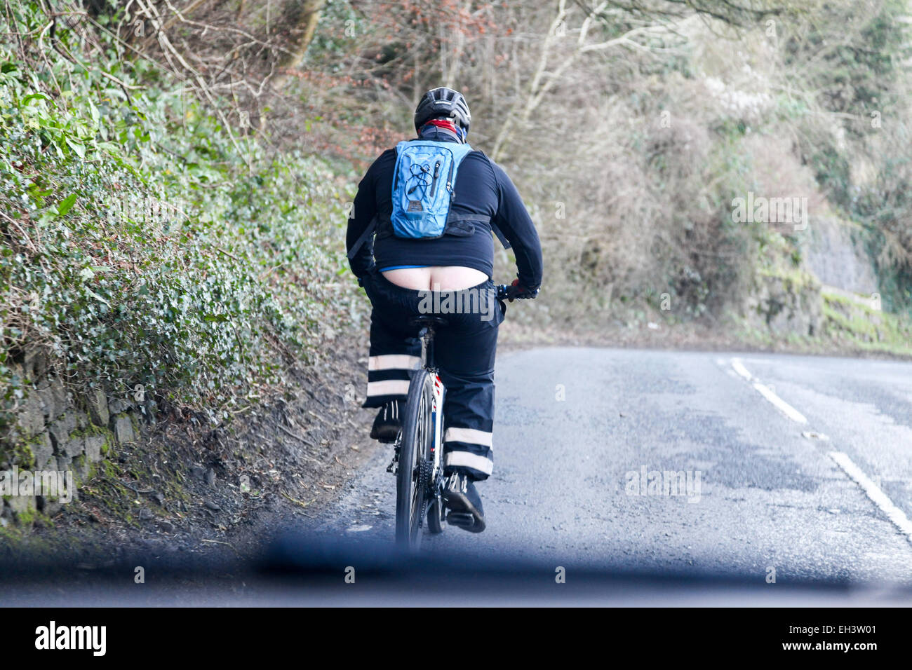 Ein Übergewicht Radfahrer seiner Bum oder unteren Spaltung zeigen, während Radfahren Stockfoto