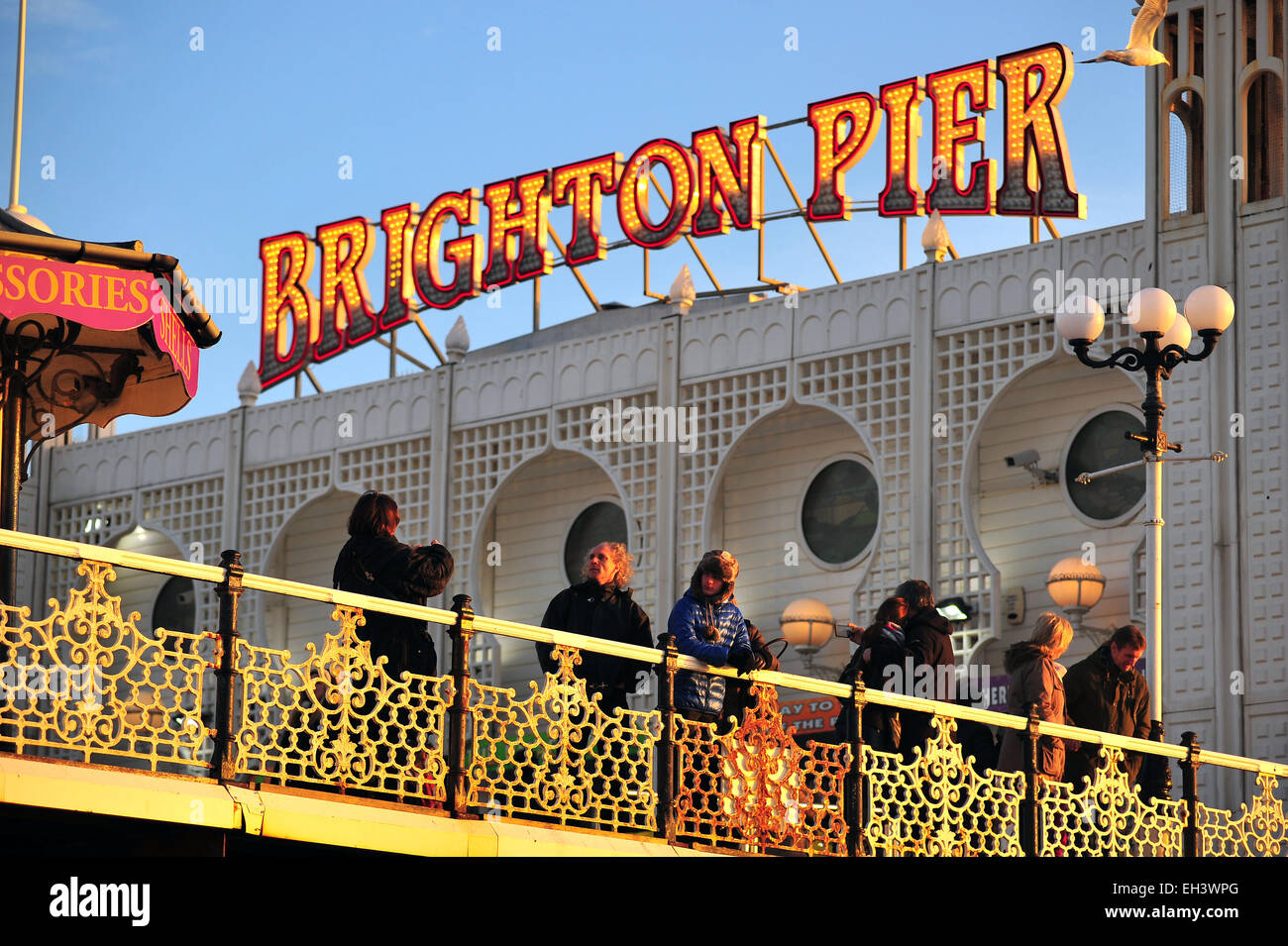 Menschen stehen am Pier von Brighton bei Sonnenuntergang. Stockfoto