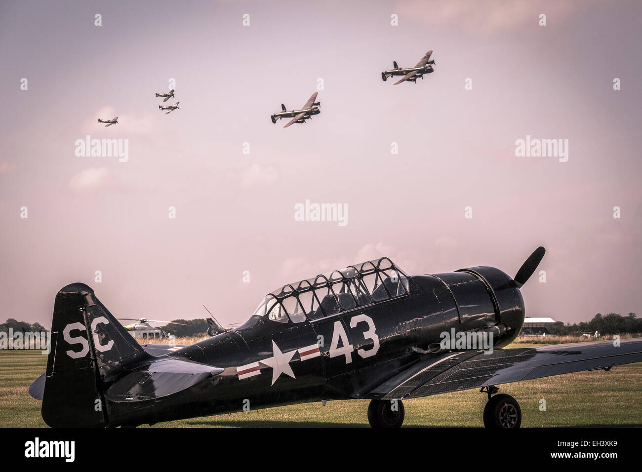 Ein 1943 Harvard IIB Flugzeug neben der Landebahn auf 2014 Goodwood Revival, Sussex, Großbritannien, als die Memorial Flight geht über Kopf. Stockfoto