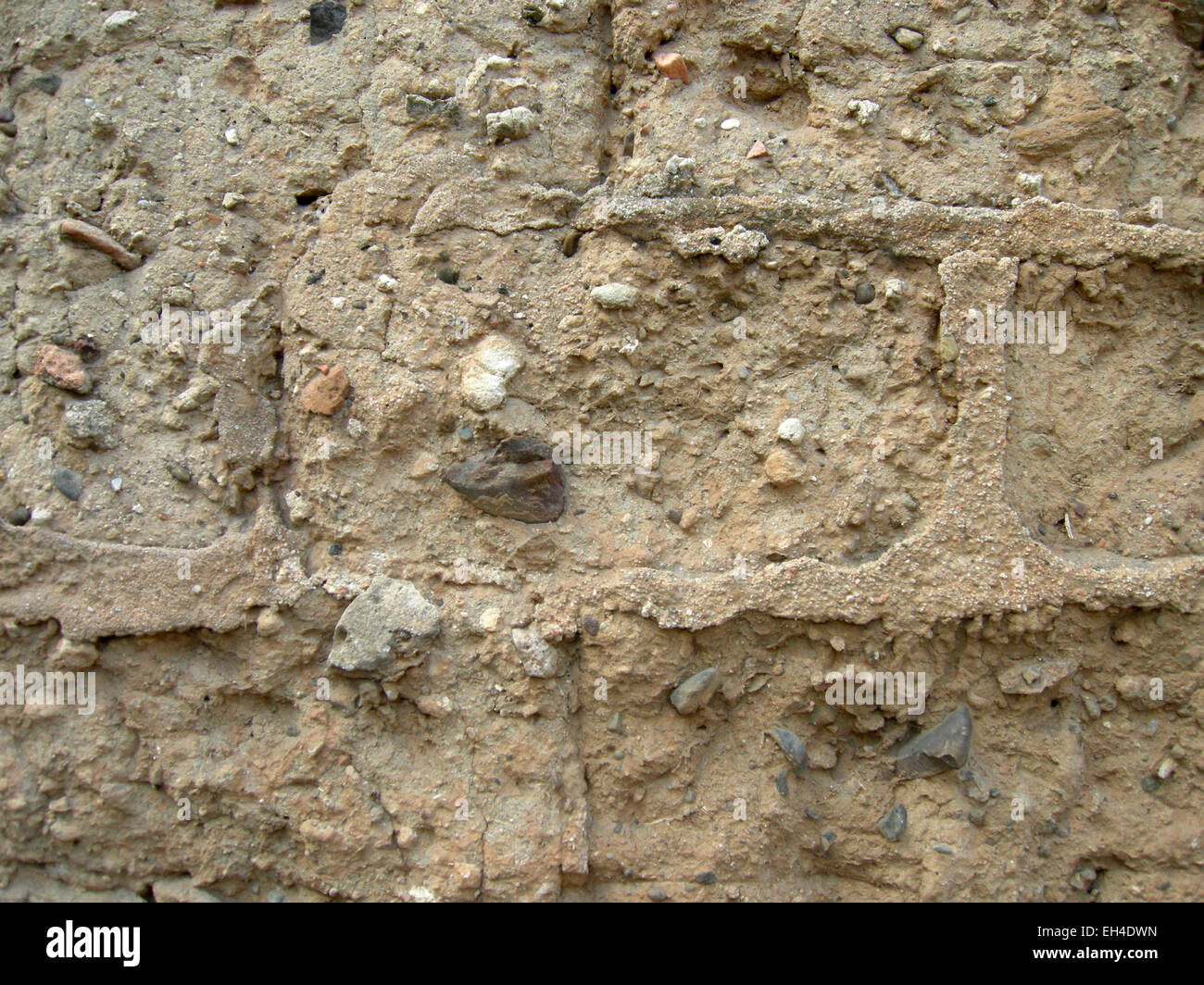 Mauer aus Lehmziegeln mit einigen kleinen Steinen und Stroh und Beton Ziegel in der traditionellen Architektur Stockfoto