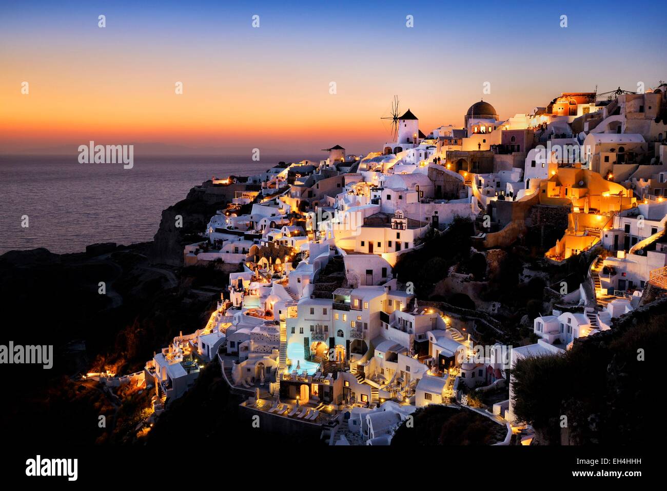 Griechenland, Kykladen, Santorini Island (Thera, Thira), Windmühlen und Dorf Oia bei Sonnenuntergang Stockfoto