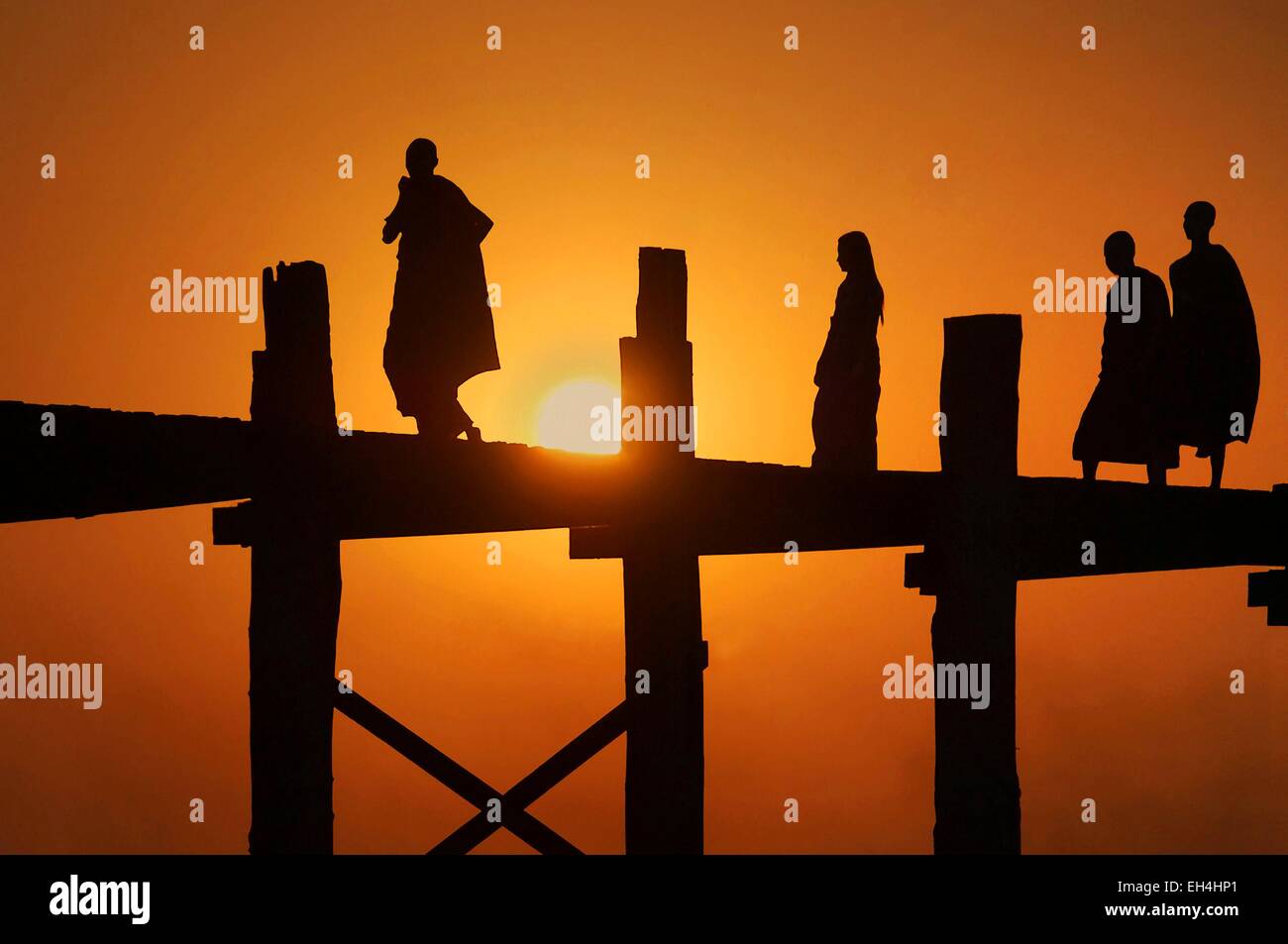 U Bein, Silhouette der Mönche auf der U Bein Brücke bei Sonnenuntergang, Amarapura, Mandalay, Myanmar Stockfoto