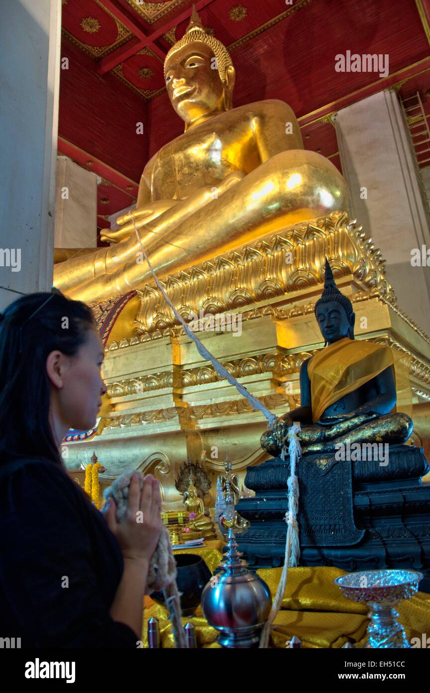 Thailand, Ayutthaya, Weltkulturerbe der UNESCO, Wihan Mongkhon, Frau beten, verbunden mit einem Seil an einem großen goldenen Buddha (Model-Release) Stockfoto
