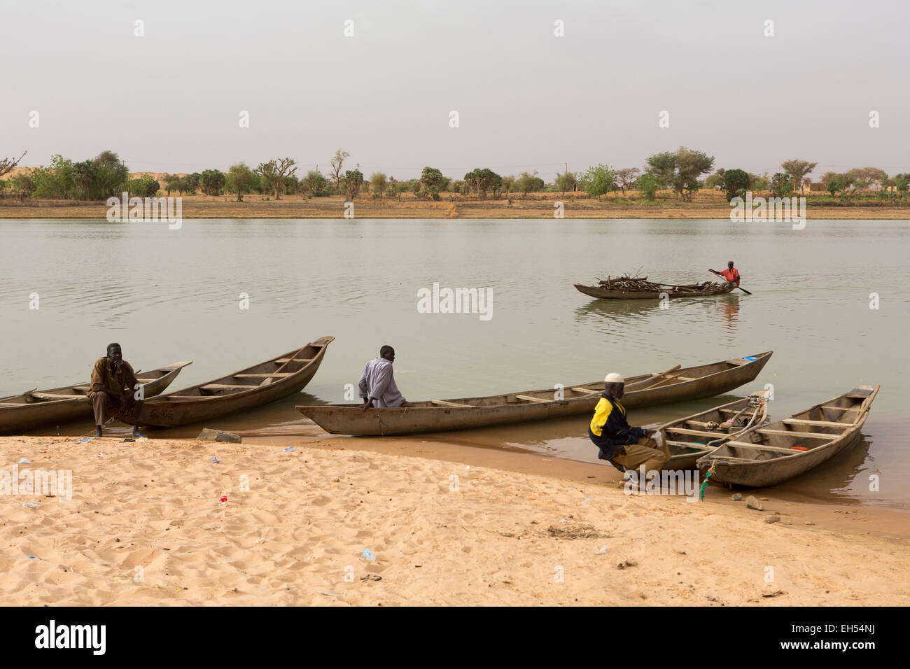 In der Nähe von NIAMEY, NIGER, 15. Mai 2012: A Fährmann trägt Brennholz flussabwärts am Fluss Niger. Stockfoto