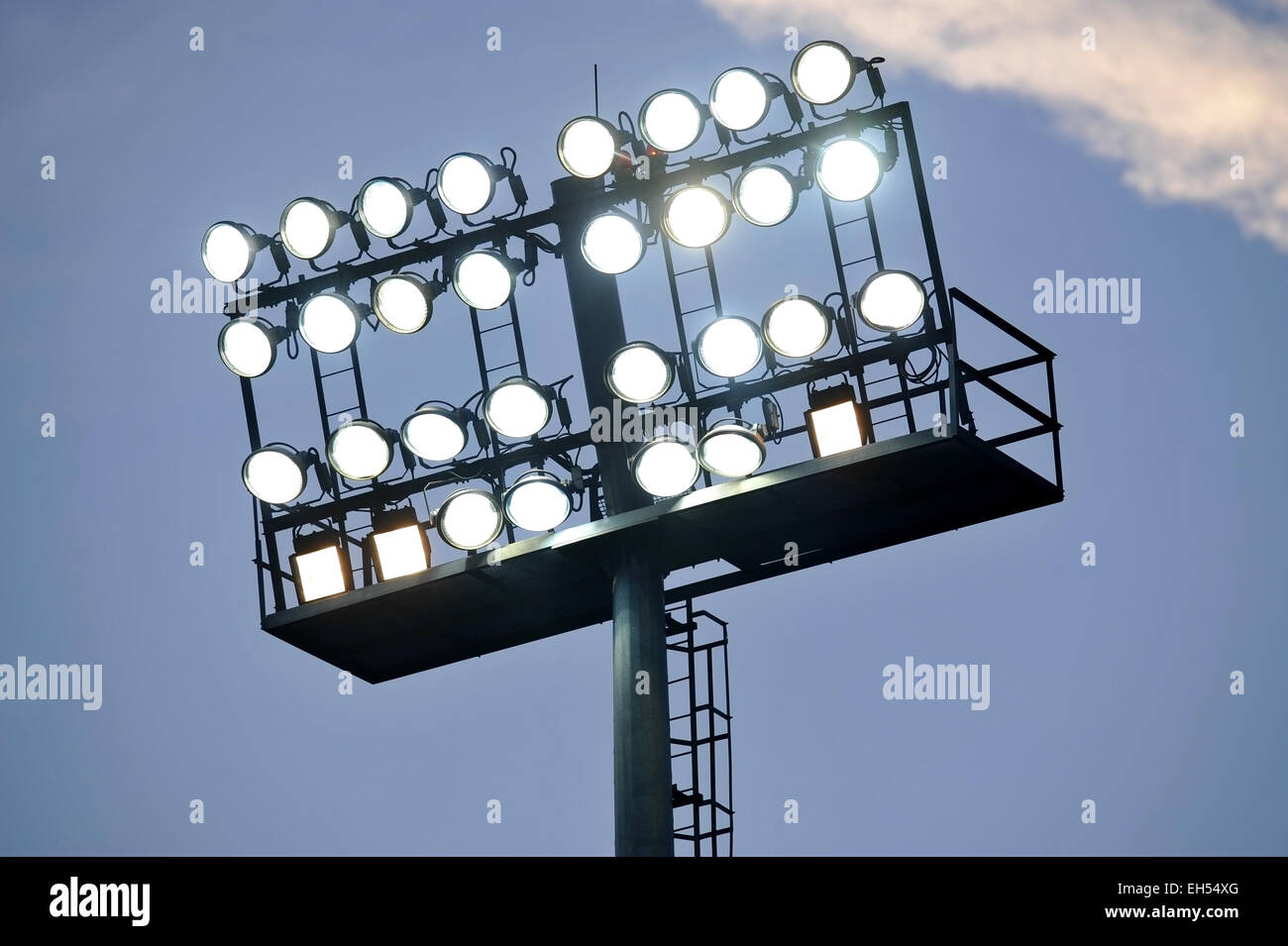 Fußball-Stadion-Scheinwerfer eingeschaltet bei Sonnenuntergang Stockfoto