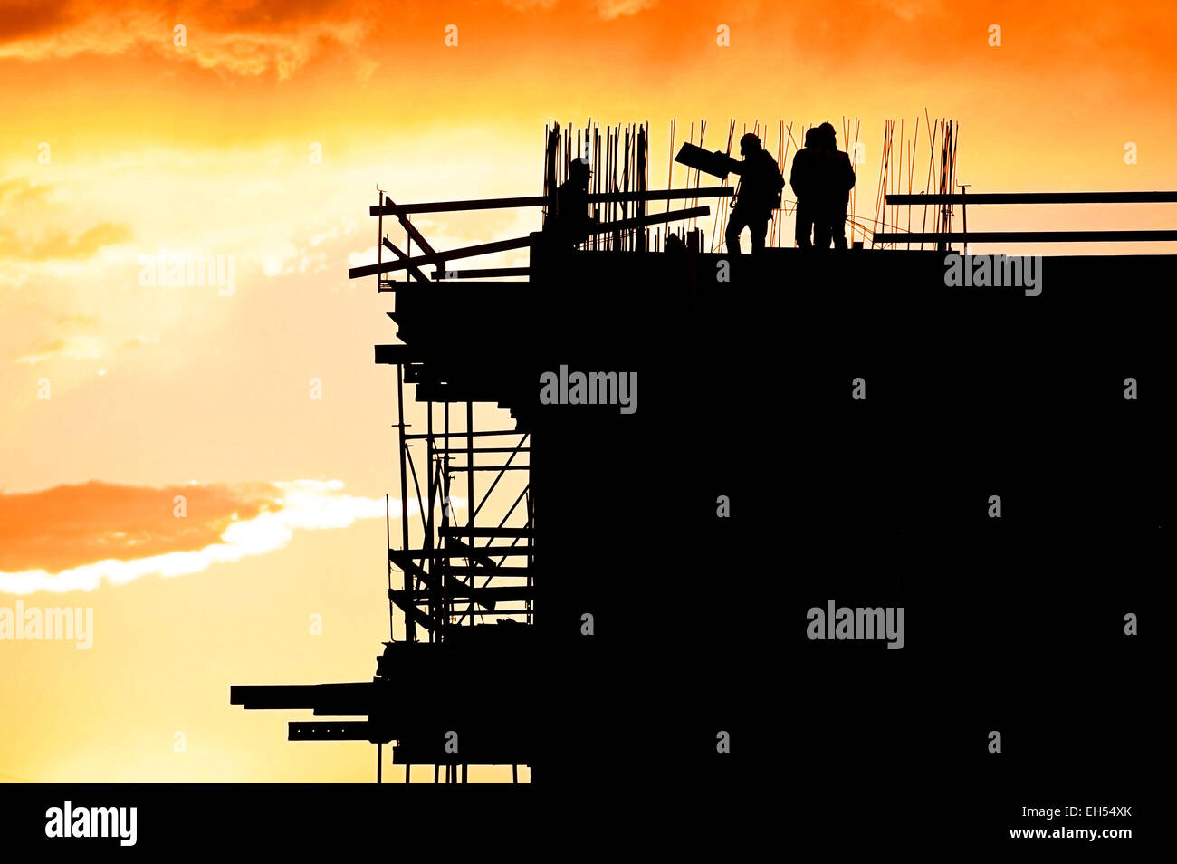 Bau-Arbeiter-Silhouetten auf einer Baustelle bei Sonnenuntergang Stockfoto
