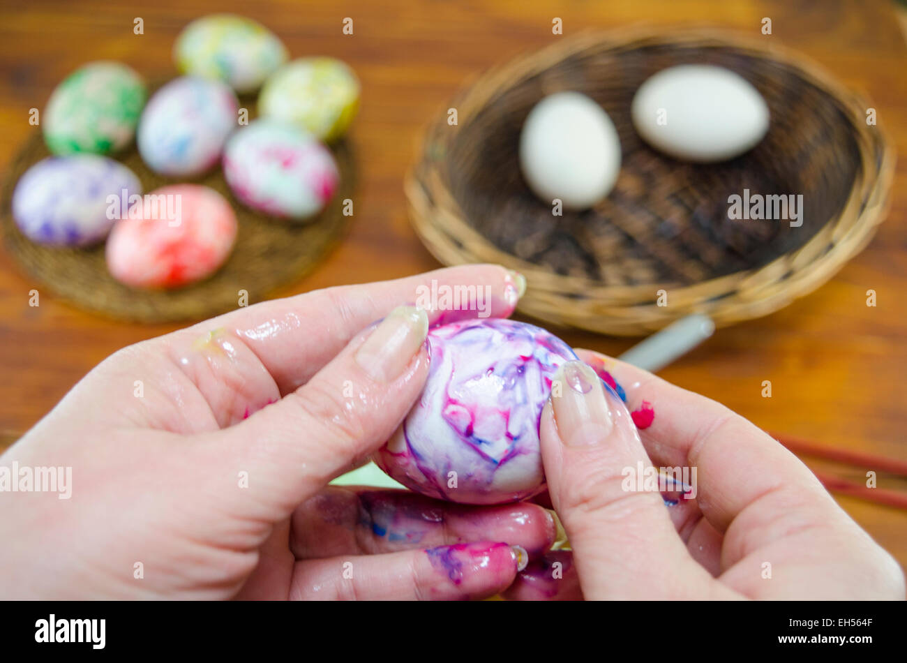 Die Hände von Frauen ein Ei mit den Fingern malen Stockfoto