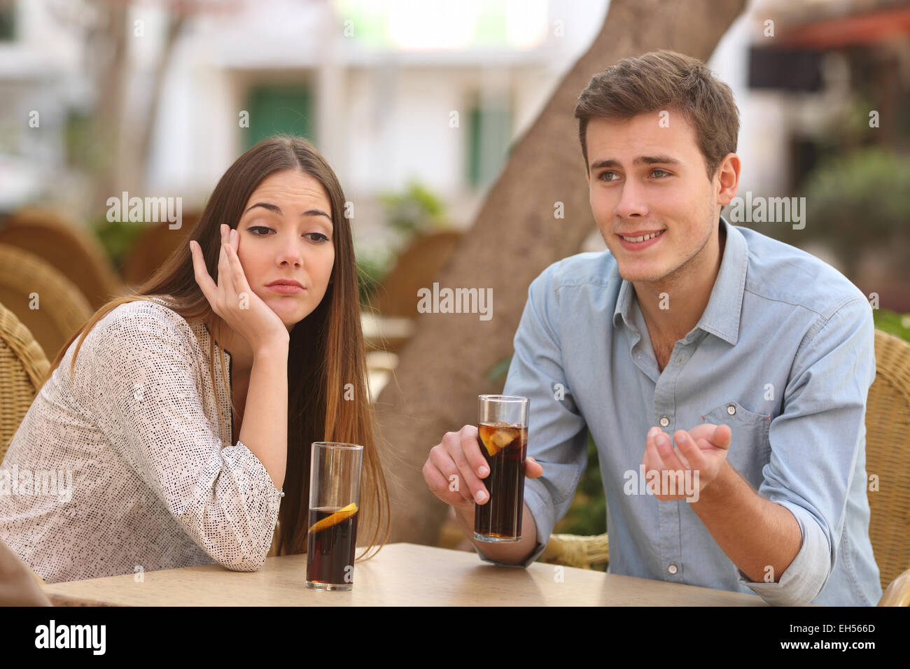 Mann und Frau in einem Restaurant aus Terrasse, aber sie ist langweilig, während er spricht Stockfoto