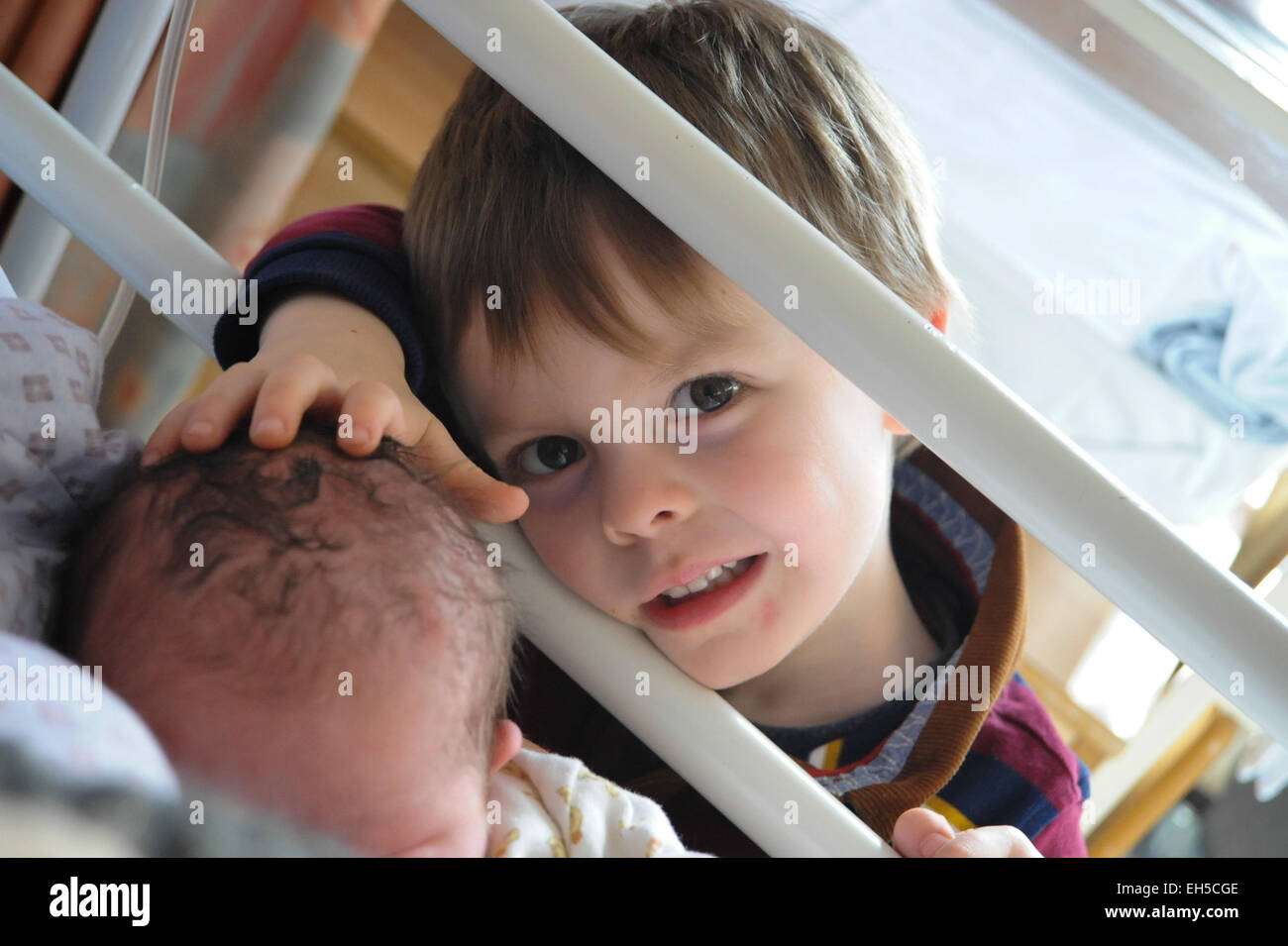 Ein großer Bruder trifft seinen Neugeborenen kleinen Baby Bruder zum ersten Mal im Krankenhaus Stockfoto