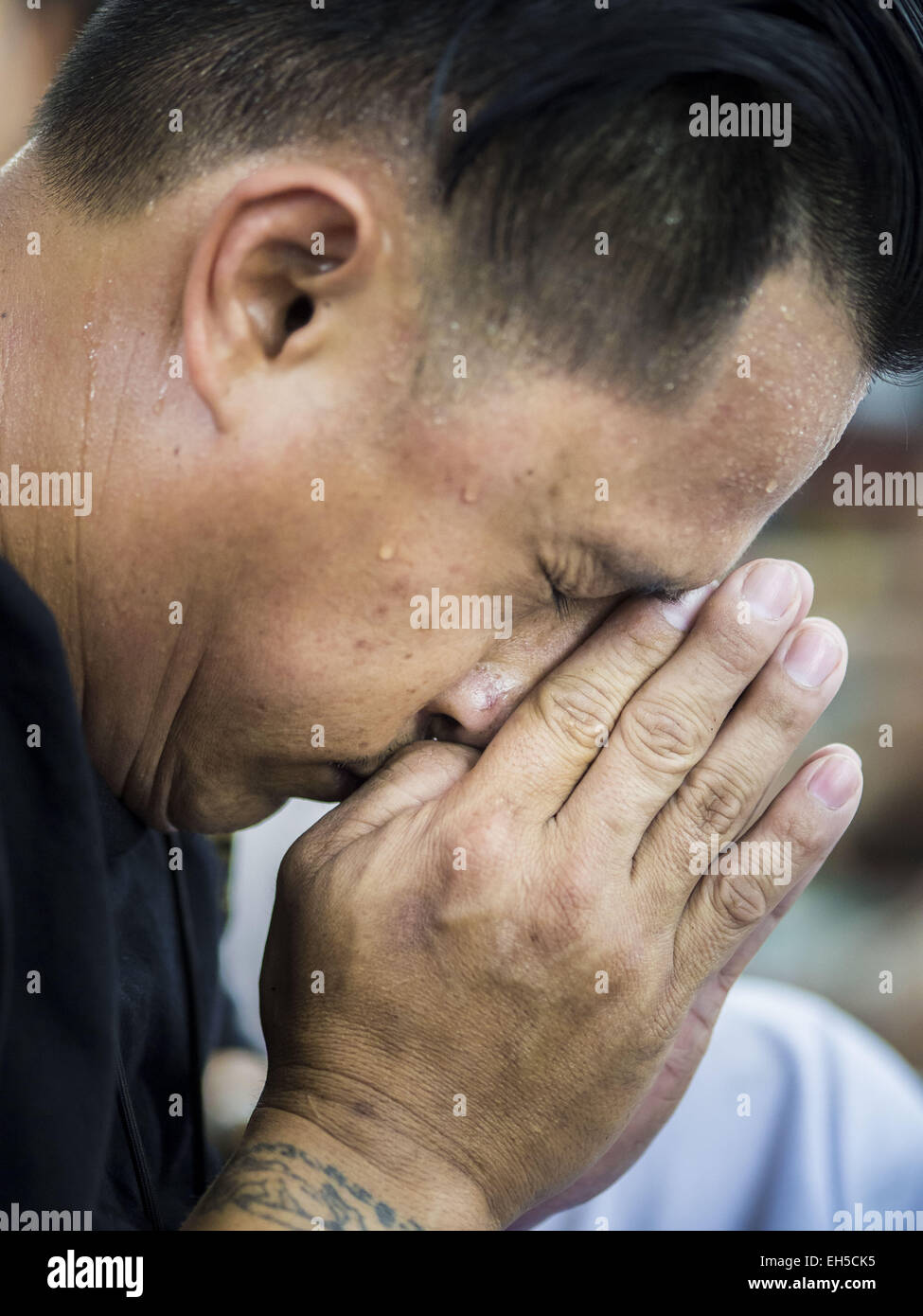 Nakhon Chai Si, Nakhon Pathom, Thailand. 6. März 2015. Ein Mann betet nach dem Aufstehen eines neuen Tattoo auf dem Wat Bang Phra Tattoo Festival. Wat Bang Phra ist der bekannteste '' Sak Yant''-Tattoo-Tempel in Thailand. Es befindet sich in Nakhon Pathom Provinz, ungefähr 40 Meilen von Bangkok. Die Tattoos sind mit hohlen Edelstahl-Nadeln und werden gedacht, um die magischen Kräfte des Schutzes zu besitzen. Bildnachweis: ZUMA Press, Inc./Alamy Live-Nachrichten Stockfoto