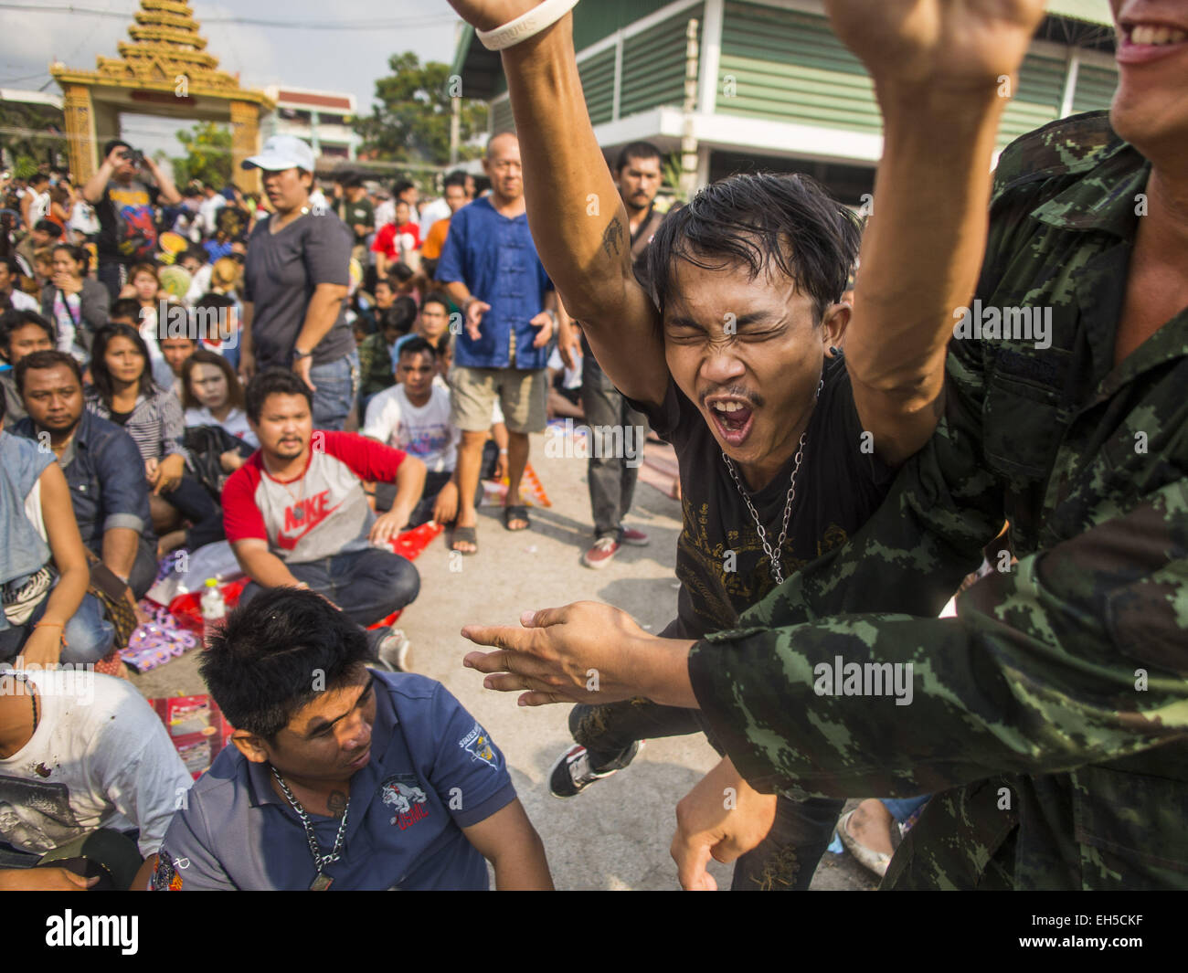 Nakhon Chai Si, Nakhon Pathom, Thailand. 7. März 2015. Ein Mann erhebt die Kanalisierung der Macht von seinem spirituellen Tattoo auf dem Wat Bang Phra Tattoo Festival Bühne. Wat Bang Phra ist der bekannteste '' Sak Yant''-Tattoo-Tempel in Thailand. Es befindet sich in Nakhon Pathom Provinz, ungefähr 40 Meilen von Bangkok. Die Tattoos sind mit hohlen Edelstahl-Nadeln und werden gedacht, um die magischen Kräfte des Schutzes zu besitzen. Bildnachweis: ZUMA Press, Inc./Alamy Live-Nachrichten Stockfoto